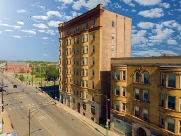 Chicago apartment for rent - A tall brick building stands on a street corner.