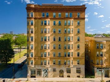 Chicago apartment for rent - A tall building with many windows and a mural on the front.
