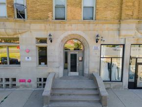 Chicago apartment for rent - A building with a grey stone facade and a black door.