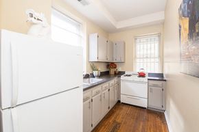 Philadelphia apartment for rent - a small kitchen with white appliances and gray cabinets