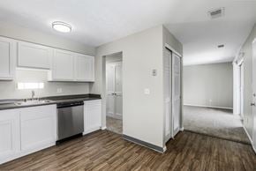 Columbus apartment for rent - A kitchen with white cabinets and a black countertop.