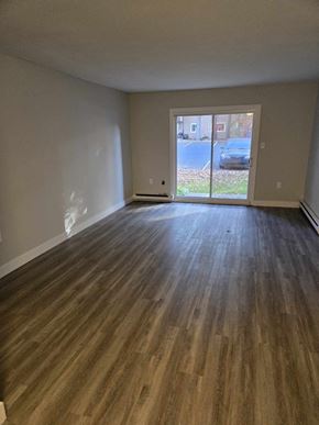 Bedford apartment for rent - a living room with a wood floor and a door to a patio