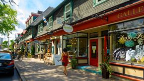Halifax apartment for rent - A woman in a red dress is walking down a street past a storefront with a sign that says "GALLE".