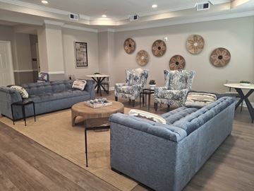Tampa apartment for rent - A living room with a grey sofa, two chairs and a coffee table.