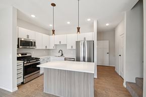 Medina townhouse for rent - A modern kitchen with white cabinets and a large island at Ironwood Townhomes in Medina, MN.