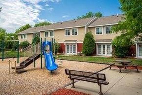 Burnsville townhouse for rent - a playground in front of a house with a blue slide