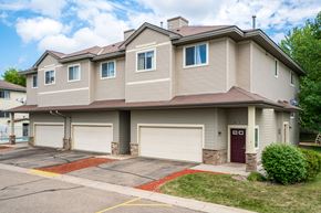 Savage townhouse for rent - a tan and brown house with two garage doors