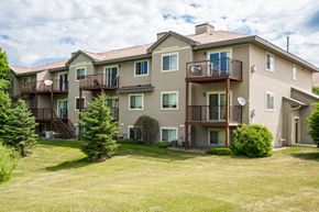 Savage townhouse for rent - the view of an apartment building with a lawn and trees