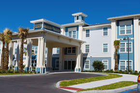 Spring Hill apartment for rent - a large building with palm trees in front of it