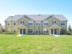 Ruskin apartment for rent - a large house with blue doors and a green lawn