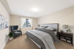 Chanhassen apartment for rent - A bedroom with a large bed and a chair.