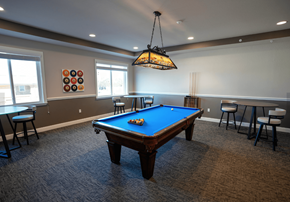 Cape Coral apartment for rent - A pool table in a room with a hanging light fixture.