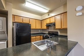 San Antonio apartment for rent - A kitchen with black appliances and wooden cabinets.