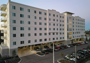 Cape Coral apartment for rent - A large white building with a parking lot in front.