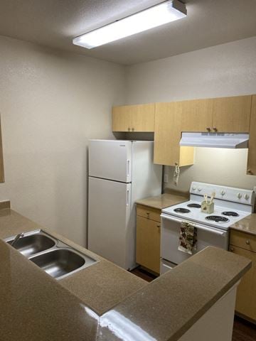 Pflugerville apartment for rent - a kitchen with a stove refrigerator and a sink