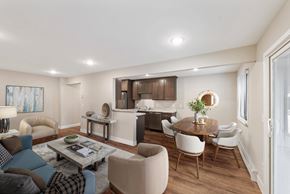 Chanhassen apartment for rent - A modern living room with a dining area and kitchen in the background.