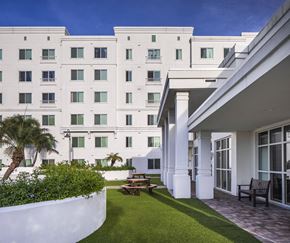 Tampa apartment for rent - a courtyard with a table and chairs in front of a white building