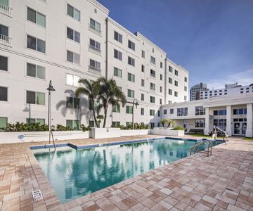 Tampa apartment for rent - a swimming pool in front of a white building