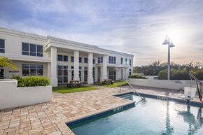 Tampa apartment for rent - a swimming pool with a building in the background