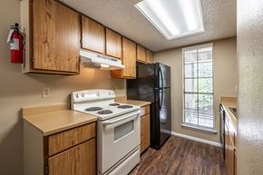 San Antonio apartment for rent - A kitchen with a white stove and black refrigerator.