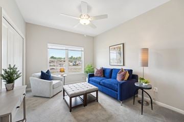 Monticello triplex for rent - a living room with a blue couch and chair and a ceiling fan
