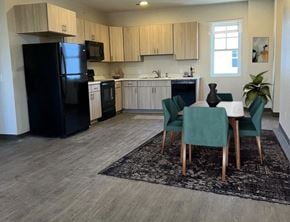 Windom apartment for rent - a kitchen with a table and chairs and a black refrigerator