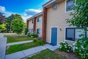 Golden Valley townhouse for rent - a side view of a house with a blue door and a sidewalk