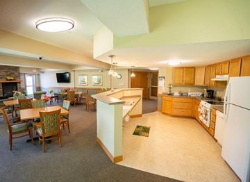 Oakdale apartment for rent - A kitchen with a white refrigerator and wooden chairs.