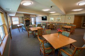 Oakdale apartment for rent - A large wooden table is surrounded by chairs in a room with a stone fireplace.