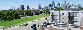 Minneapolis triplex for rent - A cityscape with a building in the foreground and a highway in the background.
