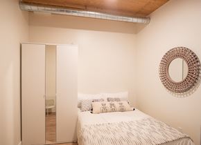 Oakland apartment for rent - a small bedroom with a bed and a mirror