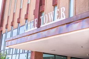 New Orleans apartment for rent - the facade of the office tower building with a sign on the front of it