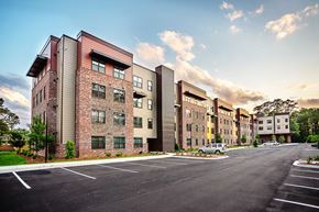 Valdosta apartment for rent - A large apartment complex with a parking lot in front.