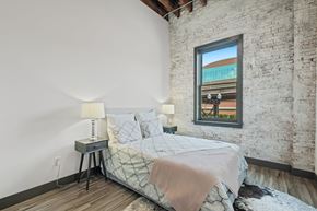St. Louis apartment for rent - a bedroom with a bed and a exposed brick wall