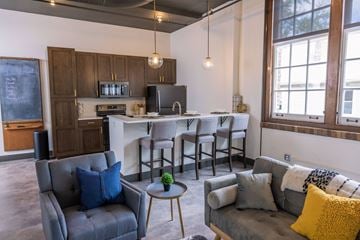 St. Louis apartment for rent - a living room with a kitchen with a bar and couches
