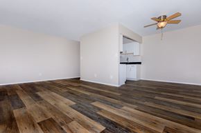 Willoughby apartment for rent - an empty living room with a ceiling fan and a kitchen in the background