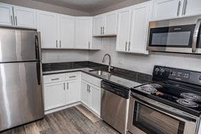 Parma apartment for rent - a kitchen with white cabinets and stainless steel appliances