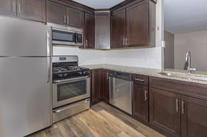 Westlake apartment for rent - a kitchen with dark wood cabinets and stainless steel appliances