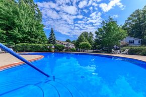 Madison apartment for rent - a large blue pool with a slide and trees in the background