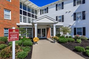 Westlake apartment for rent - a walkway leading to a building with a sign that reads westfield leasing office