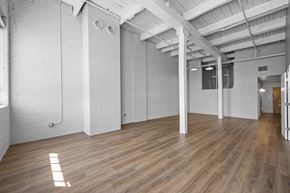Cleveland apartment for rent - A spacious room with wooden floors and white walls.