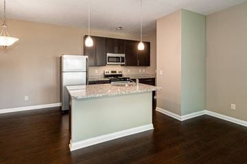 New Albany apartment for rent - A kitchen with a refrigerator, microwave, and stove top oven.