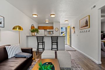 Toledo apartment for rent - A living room with a brown leather couch and a gold floor lamp.