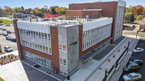 Painesville apartment for rent - A large building with a parking lot in front of it.