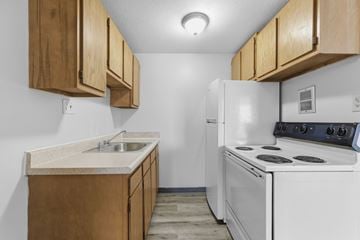 Cleveland apartment for rent - A kitchen with a white stove and wooden cabinets.
