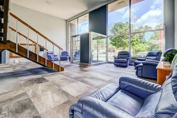 Parma Heights apartment for rent - a living room with blue couches and chairs and a staircase
