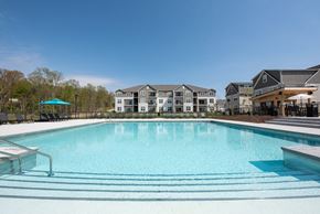 Lancaster apartment for rent - a swimming pool with apartments in the background at The Bend, Lancaster, Ohio