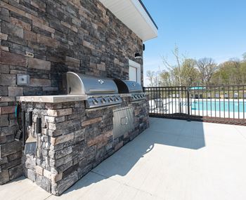 The outdoor grill area of a house with a swimming pool