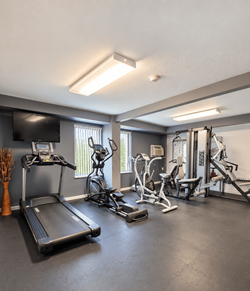 Parma Heights apartment for rent - A spacious gym with a variety of equipment including treadmills, stationary bikes, and weight machines.