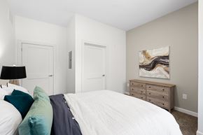 Cleveland apartment for rent - A bedroom with a white bed and a painting on the wall. at The Lumos Apartments, Cleveland